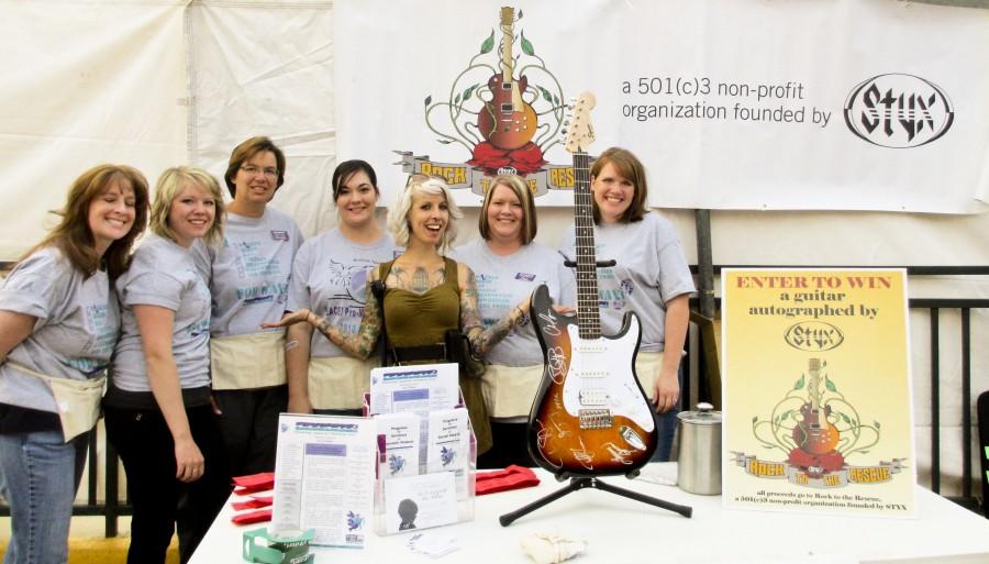 Hannah Shaw executive director of Rock to the Rescue (center) partner with Rapid City WAVI volunteers from Left: Kelley Crane, Mallory Heutzenroeder, Mary Corbine (Executive Director of WAVI), Rebekkah Kruse, Ruth Torala and Morgan VonHaden to manage raffle ticket sales.