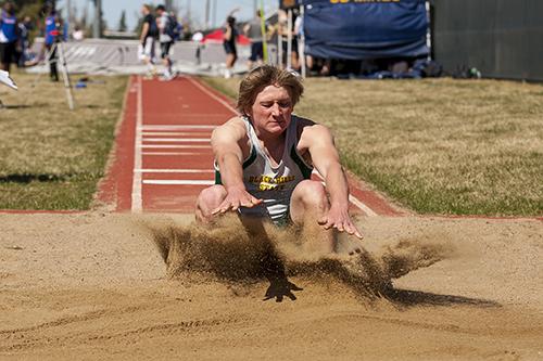 Ryan Mehalick lands in the sand pit during the men's long jump event.