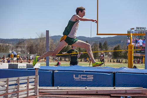Mitch Kraft clears the hurdle before landing in the water pool during the men's steeplechase.