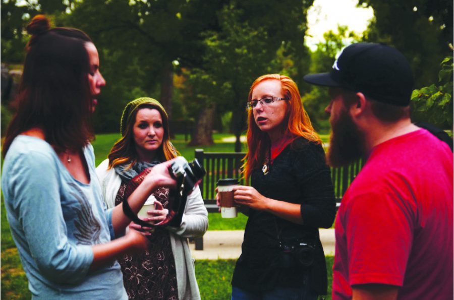 Taylor Stone (third from left) assists fellow club member with her film camera. 