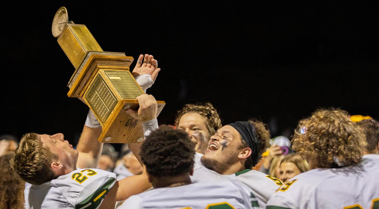 Safety Bailey Rosenstrauch lifts Homestake Trophy with teammates.		 						