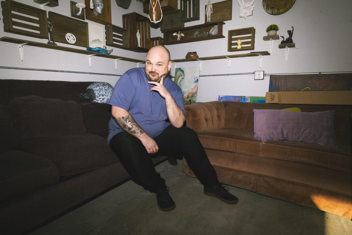 Cameron Stalheim poses on the couch in his backyard studio in Sioux Falls, South Dakota.